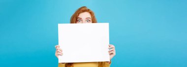 Boş işaret gösteren gülümseyen portre genç güzel çekici Kızıl kızıl saçlı kız kadar yakın. Mavi Pastel renkli. Kopya alanı