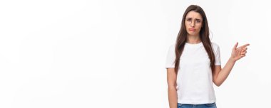 Üzgün, hayal kırıklığına uğramış, gözlüklü, parmağını sağa çevirip kameraya somurtan, tedirgin ve pişmanlık duyan, kaçırılan bir şans için yas tutan, beyaz arka planda oturan aptal bir kız..