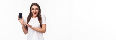 İletişim, teknoloji ve yaşam tarzı kavramı. Gözlüklü sevimli hippi kızın portresi, yeni başvuru formu, mobil uygulaması, internetten alışveriş merkezi yüklemesi, akıllı telefonu bekletmek..