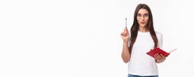 Yaratıcı hevesli genç bayanın harika bir fikri var, not defterine unutmamak için, kalemini Eureka işareti ile yükseltmek, heyecanla gülümsemek, hazırlık planı veya günlük program, beyaz arka plan.