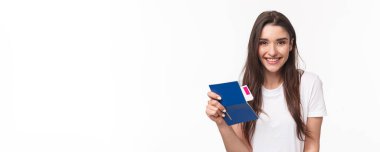 Seyahat, tatil, yaz konsepti. Yakın plan portre güzel uzun saçlı genç kadın, havaalanında oturan yolcu, elinde pasaport ve uçak bileti, tatile gidiyor, beyaz arka plan.