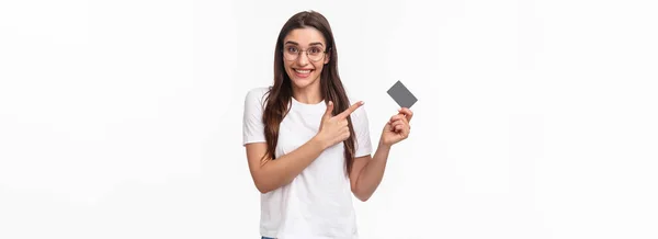 興奮し 幸せな若い女性の肖像画は クレジットカードや笑顔のカメラを指して 彼女の銀行について話して アドバイスは 非現金支払いのためにこれを使用し 商品をオンラインで購入し 白い背景 — ストック写真