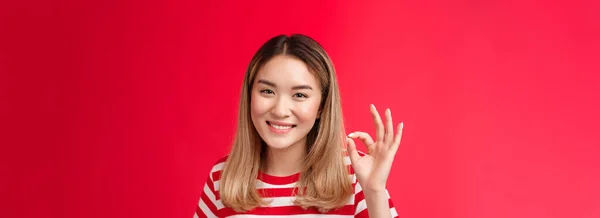 親身な満足屈託のない若いアジアのブロンドの女の子ショー承認判断サイン大丈夫 同意する計画良い笑顔広くあなたのアイデアのように満足素晴らしい選択 スタンド赤の背景喜んで — ストック写真