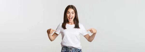 Захоплена Щаслива Брюнетка Дівчина Посміхається Вказуючи Пальці Логотип Показуючи Банер — стокове фото
