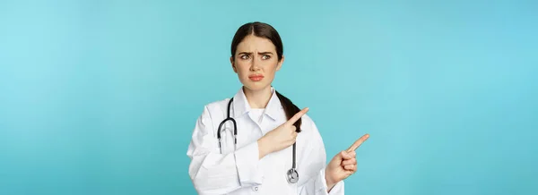 Confused Disappointed Medical Worker Frowning While Pointing Fingers Left Doubtful — Fotografia de Stock