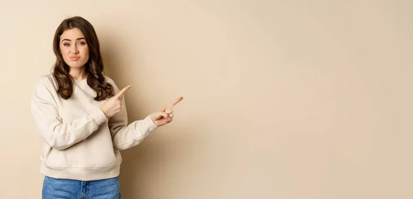 Şüpheci Kız Tereddütlü Görünüyor Parmaklarını Logoya Işaret Ediyor Reklam Metni — Stok fotoğraf