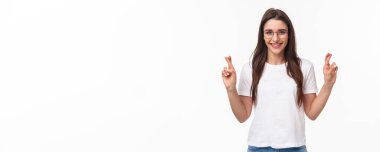 İyimser kızın belden yukarı portresi rüyaların gerçek olduğuna inanır, gözlük takar ve tişört giyer, şans diler, dilek tutar, dua eder ve olumlu sonuçlar bekler, beyaz arka plan.
