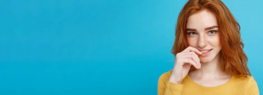 Kameraya gülümseyen kızıl saçlı mutlu kızıl saçlı kızın portresi. Pastel mavi arka plan. Boşluğu Kopyala