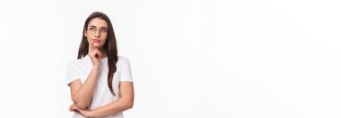 Yaratıcı genç bir kadının belden yukarı portresi, dijital sanatçı yeni bir proje görüntülüyor, gözlük takıyor, düşünceli, düşünceli, dokunaklı çene düşünen, plan yapan, beyaz arka planda duruyor..