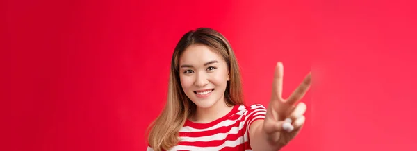 楽観的な肯定的な若いアジアの女性は Lbtコミュニティをサポートし 前方の平和の勝利のサインを見る手を引くと 喜んで幸運な感じ笑みを浮かべて 赤の背景喜びをスタンド 夏休みをお楽しみください — ストック写真