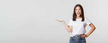 Heyecanlı güzel kız kolunu uzat, elinde bir şey tut ve mutlu görün..