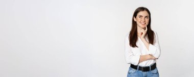 Portrait of female entrepreneur thinking, making choice, standing thoughtful, white studio background.