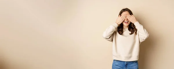 stock image Excited happy girl smiling, close eyse and wait for surprise gift, standing blinsided over beige background.