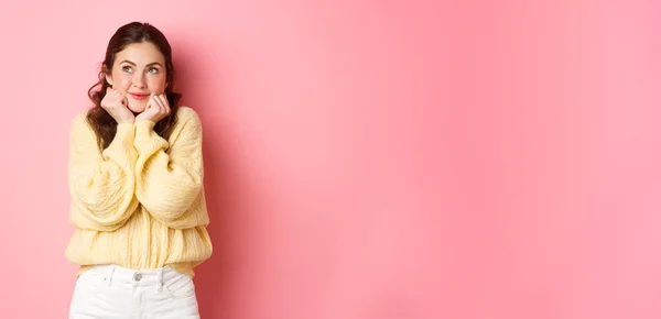 stock image Beautiful glamour girl thinking about love, looking up and daydreaming, imaging something cute and romantic, standing against pink background.