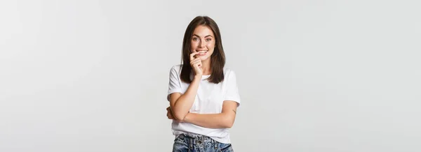 Sonriente Chica Atractiva Mordiendo Dedo Mirando Con Tentación Fondo Blanco — Foto de Stock