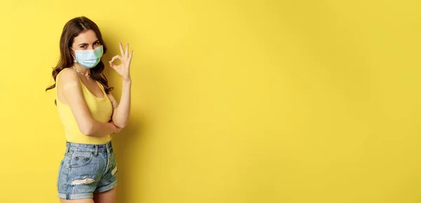 年轻女性的肖像包括接种疫苗 感染流感疫苗 戴口罩 表现出良好的体征 建议注射疫苗 女孩肩部贴有疫苗 站在黄色背景上 — 图库照片