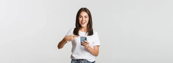 Excited Pleased Brunette Girl Pointing Finger Smartphone Screen — Stock Photo, Image