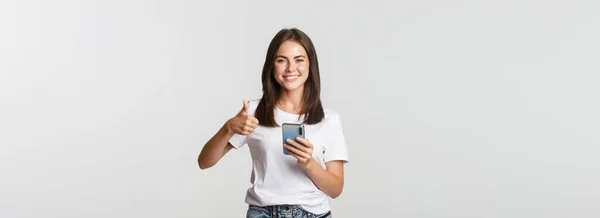 Tevreden Glimlachende Jonge Vrouw Tonen Duimen Tijdens Het Gebruik Van — Stockfoto