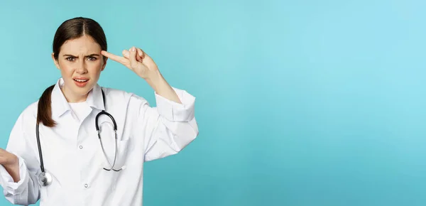Zdenerwowana Kobieta Lekarz Wskazując Palcem Głowę Skarcąc Kogoś Głupi Szalony — Zdjęcie stockowe