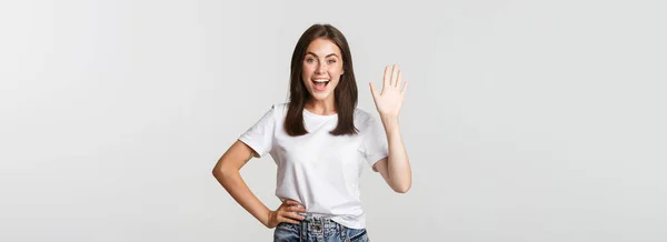 Freundlich Lächelndes Mädchen Winkt Mit Der Hand Und Grüßt Jemanden — Stockfoto
