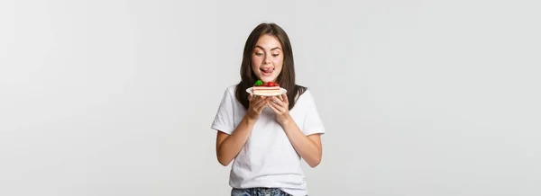 Güzel Bir Kızın Portresi Dudaklarını Yalıyor Pastaya Bakıyor — Stok fotoğraf