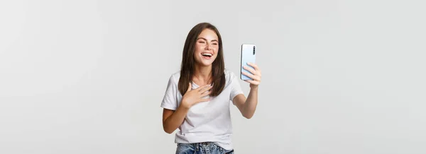 優しい笑顔の女性のビデオ通話やスマートフォンの幸せな話 立って白い背景 — ストック写真