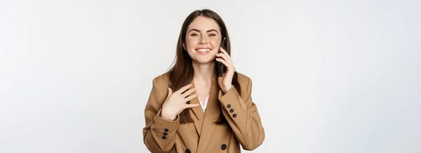 打电话 用智能手机交谈 与客户交谈 穿着棕色西服站在白色背景之上的女商人 — 图库照片