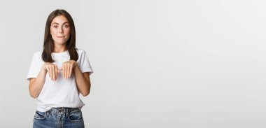 Aptal ve sevimli esmer kız gülümsüyor ve köpek pozu veriyor..