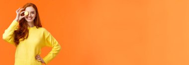 Rejimi unut, keyfine bak. Neşeli ve mutlu, gülümseyen kızıl saçlı kadın, küçük tatlı kurabiyeleri gözünün üstünde tutuyor ve sırıtıyor, kendi tatlarını pişiriyor, harika bir kafeyi lezzetli yemeklerle destekliyor..