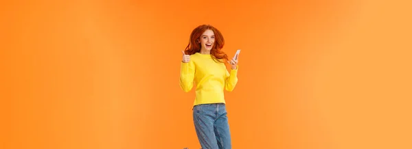 Pionowa Beztroska Podekscytowana Zadowolona Ruda Dziewczyna Swetrze Dżinsach Skacząca Pomarańczowym — Zdjęcie stockowe