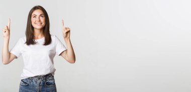 Çekici, gülümseyen esmer kız parmaklarını kaldırıp logoyu gösteriyor..