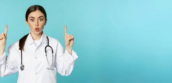 의사가 손가락을 치켜들고 놀라서 표정으로 광고를 거북의 위에서 — 스톡 사진