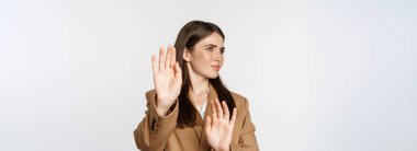 Embarrassed woman turn away from something disgusting, refusing, rejecting, standing displeased against white background.