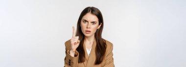 Angry corporate woman, boss shaking finger disapproval, scolding someone, prohibit something, standing over white background.