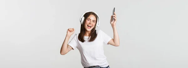 Feliz Hermosa Chica Morena Bailando Escuchando Música Auriculares Inalámbricos Sosteniendo —  Fotos de Stock