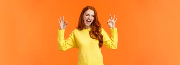 明るくポジティブな 熱狂的な赤毛の女性黄色のセーターの承認では 喜んで笑みを浮かべて 許可を与える 肯定的な応答 レート良い映画 うなずきの合意 お勧めします オレンジの背景 — ストック写真