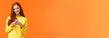 İletişim, insanlar ve sohbet konsepti. Tasasız modern hippi kız akıllı telefon uygulamasında filtrelerle fotoğrafları düzenler, sohbet için uygulama kullanın, gülümseyen cep telefonu görüntüsü, turuncu arkaplan.