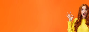 Şaşırmış ve etkilenmiş kırmızı saçlı mavi gözlü, kıvırcık saçlı kadın, çiller harika jestleri olan, ağzı açık, şaşkınlıktan ağzı açık, kameraya bakan, büyüleyici filmi onaylayan..