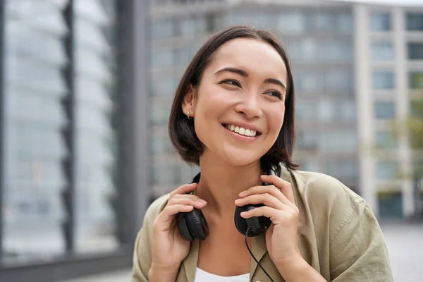 Retrato Chica Asiática Sonriente Con Auriculares Posando Centro Ciudad Escuchando —  Fotos de Stock