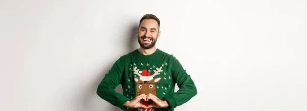 休日やお祝い ハートサインを示すクリスマスセーターで幸せな髭の男 愛とケアを表現 白い背景の上に立って — ストック写真