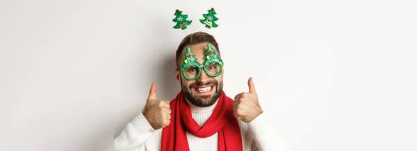 新年和庆祝理念 大胡子帅哥的特写镜头 戴着滑稽的派对眼镜 看上去很开心 大拇指伸出来表示赞同 就像什么 白色背景 — 图库照片