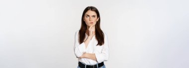 Portrait of female entrepreneur thinking, making choice, standing thoughtful, white studio background.
