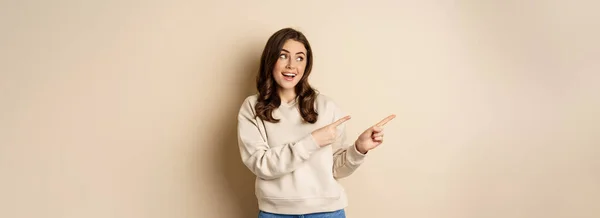 Cheerful Attractive Female Model Pointing Fingers Left Showing Store Advertisement — Foto de Stock