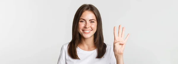 Close Alegre Atraente Jovem Sorrindo Mostrando Quatro Dedos Fundo Branco — Fotografia de Stock