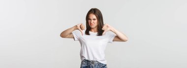 Hayal kırıklığına uğramış, suratını ekşiten tatlı kız baş parmağını kaldırıyor, hoşlanmadığını ifade ediyor..