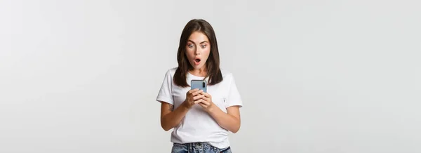 Zszokowany Pod Wrażeniem Brunetka Dziewczyna Wygląda Zdumiony Ekranie Smartfona — Zdjęcie stockowe