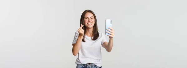 Szczęśliwa Piękna Młoda Kobieta Pokazuje Gest Serca Robi Selfie Smartfonie — Zdjęcie stockowe