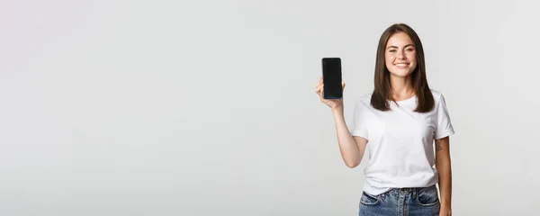 Attraktiv Leende Ung Kvinna Ser Nöjd Visar Smartphone Skärm — Stockfoto