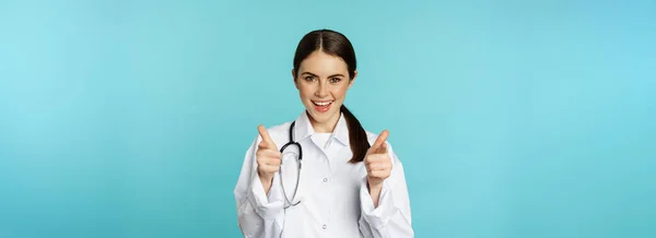 Ενθουσιασμένη Γυναίκα Γιατρός Χαμογελά Δείχνοντας Δάχτυλα Την Κάμερα Συγχαίροντας Καλώντας — Φωτογραφία Αρχείου