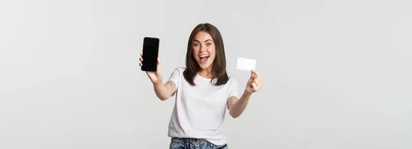 Menina Sorrindo Atraente Olhando Satisfeito Mostrando Cartão Crédito Tela Telefone — Fotografia de Stock